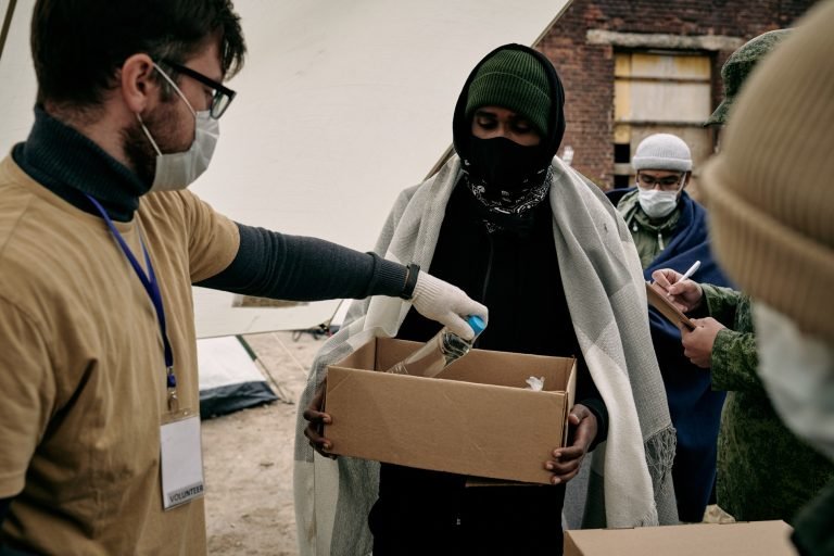 Social Workers Filling Box Of Refugees
