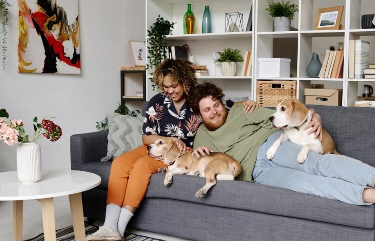 Happy couple relaxing with dogs at home
