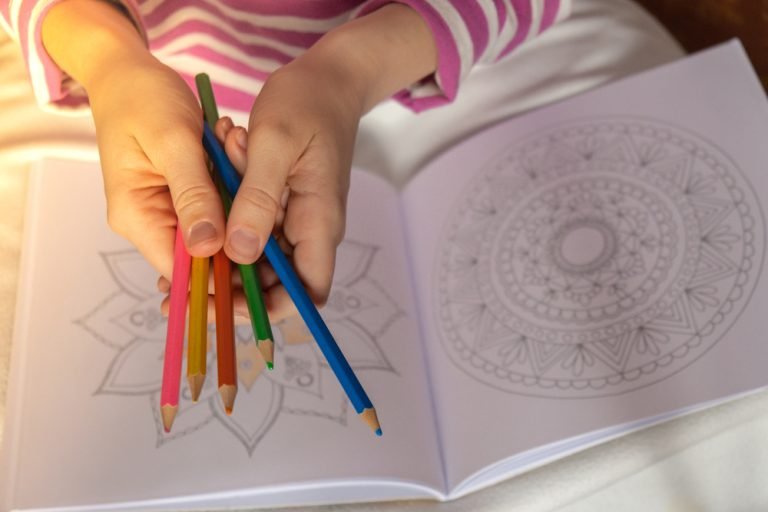 Female painting mandalas antistress page to combat stress. Relaxing hobby mental wellbeing and art therapy. Woman paints sketch, meditative process of coloring pages. Self expression by art