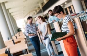 Young attractive students spending time in university library