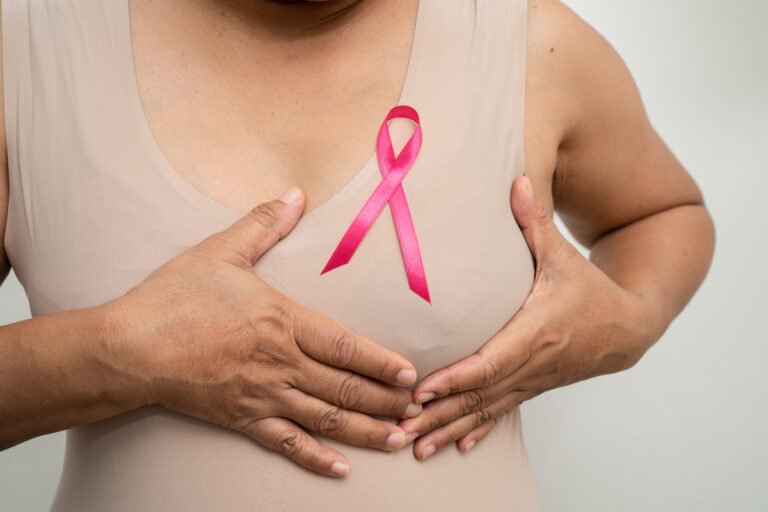 Breast cancer, pink ribbon at Asian senior lady for supporting a